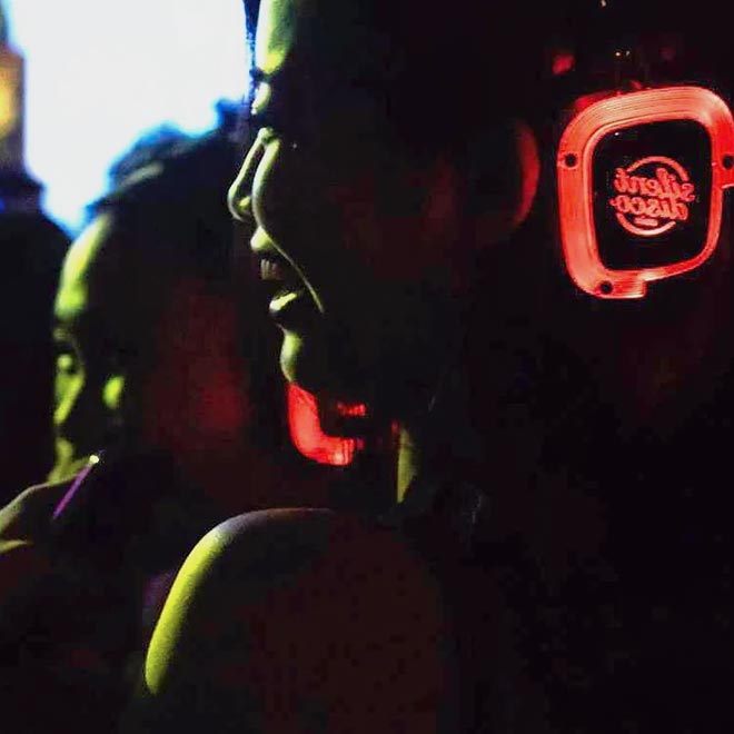 Photo of people wearing headphones with red lights